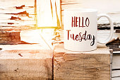 text HELLO tuesday on cup of aromatic coffee on wooden cube