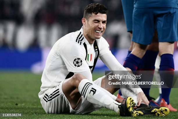 Juventus' Portuguese forward Cristiano Ronaldo reacts after being tackled during the UEFA Champions League round of 16 second-leg football match...