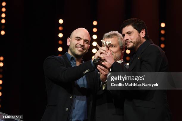 Roberto Saviano, Maurizio Braucci and Claudio Giovannesi, winner of the Silver Bear for Best Screenplay, are seen on stage at the closing ceremony of...