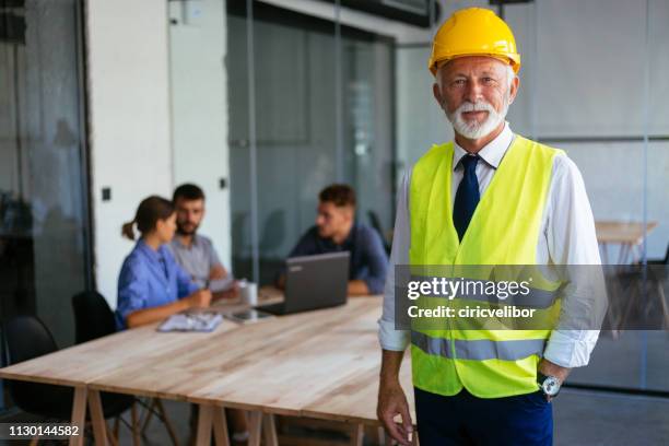 portrait of senior architect at the office - gray coat stock pictures, royalty-free photos & images