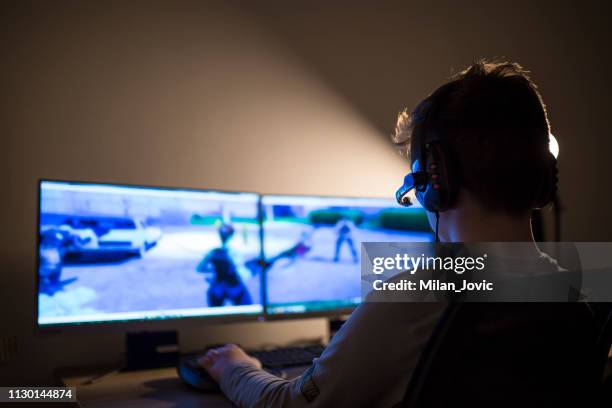 jonge jongen spelen op een computer thuis - videospel stockfoto's en -beelden