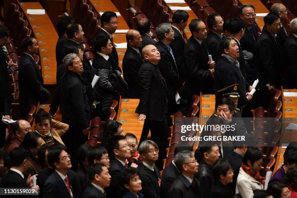 Delegates line up to leave after the closing session of the Chinese People's Political Consultative Conference at the Great Hall of the People in...