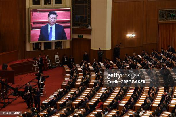 Live image of China's President Xi Jinping is seen above delegates during the closing session of the Chinese People's Political Consultative...