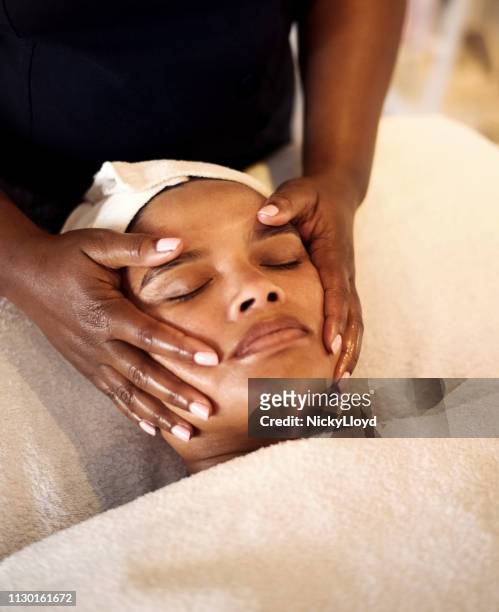 soothing facial massage - person of colour stock pictures, royalty-free photos & images