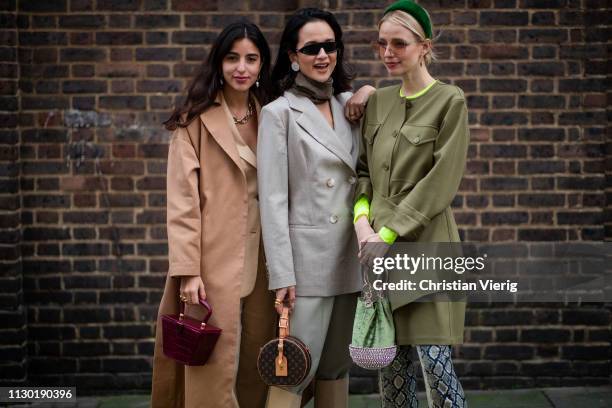 Guests and Leonie Hanne is seen wearing pants with snake print, olive jacket, hair hoop outside Toga during London Fashion Week February 2019 on...