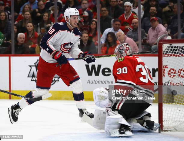 Pierre-Luc Dubois of the Columbus Blue Jackets puts the puck past Cam Ward of the Chicago Blackhawks to score a first period goal at the United...