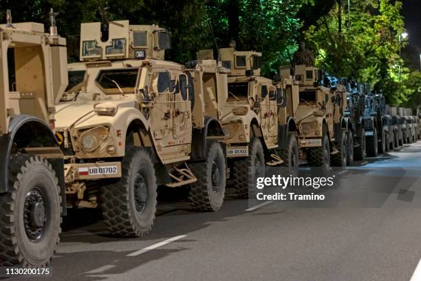 tactical vehicle oshkosh m-atv mrap vehicles parked on the street at night - military vehicle stock pictures, royalty-free photos & images