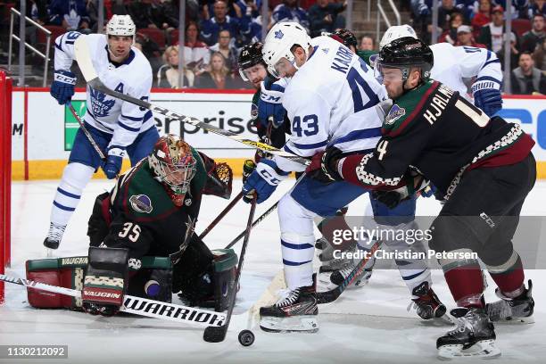 Goaltender Darcy Kuemper of the Arizona Coyotes follows the puck as Nazem Kadri of the Toronto Maple Leafs attempts a shot pressured by Niklas...