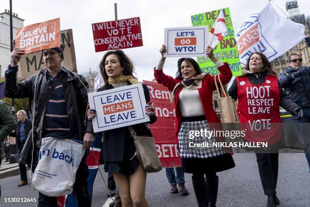 Pro-Brexit protestors carry placards during a protest near the Houses of Parliament in London on March 13, 2019. British MPs will vote Wednesday on...