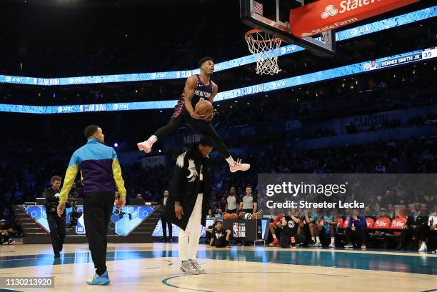 Dennis Smith, Jr. #5 of the New York Knicks jumps over Dwyane Wade as he dunks during the AT&T Slam Dunk as part of the 2019 NBA All-Star Weekend at...