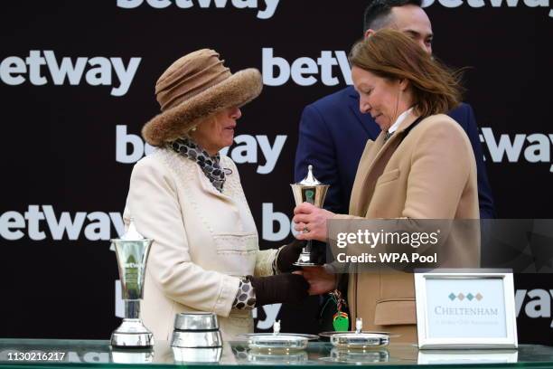 Camilla, Duchess of Cornwall presents a trophy to the owner of the winning horse, Patricia Pugh, during Ladies Day at the Cheltenham Festival at...