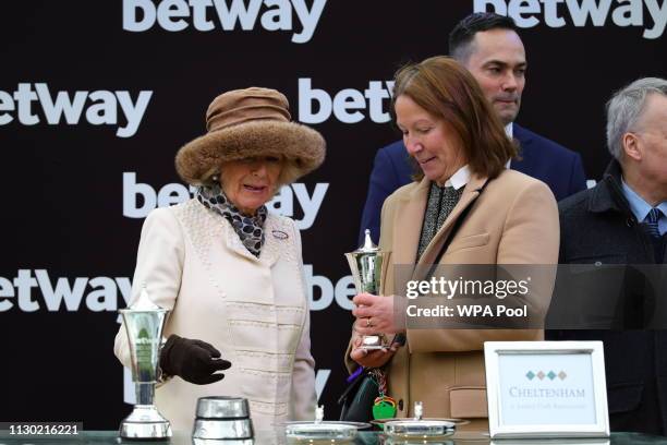 Camilla, Duchess of Cornwall presents a trophy to the owner of the winning horse, Patricia Pugh, during Ladies Day at the Cheltenham Festival at...