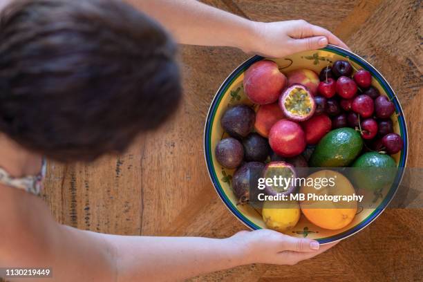arranging a fruit bowl - fruitschaal stockfoto's en -beelden