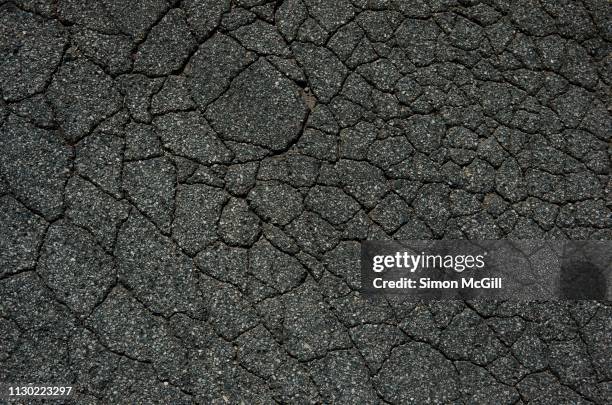 cracked asphalt road - road texture imagens e fotografias de stock