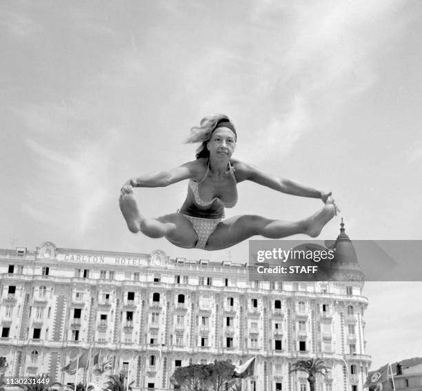 Janine Chavence, vedette de "Cherie Noire" partique sa gymnastique sur la plage du Carlton, 14 mai 1963, au festival de Cannes. Actress Janine...