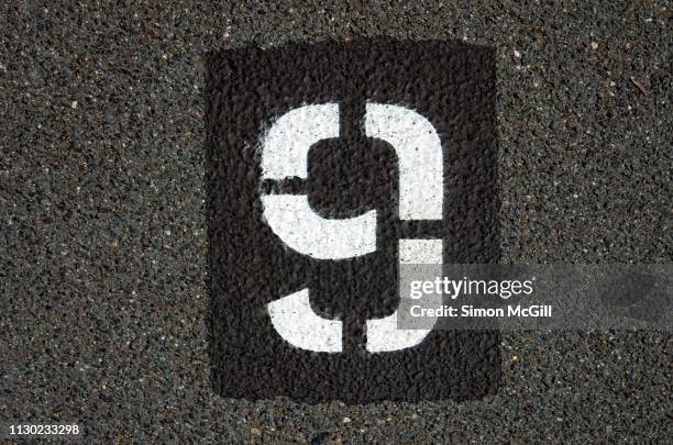 parking spot number 9 stencilled in paint on an asphalt parking lot - ninth stock pictures, royalty-free photos & images