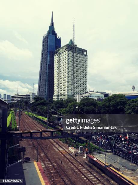 palmerah train station in jakarta, indonesia with skyscrapers in the background - indonesia electricity development in jakarta stock pictures, royalty-free photos & images