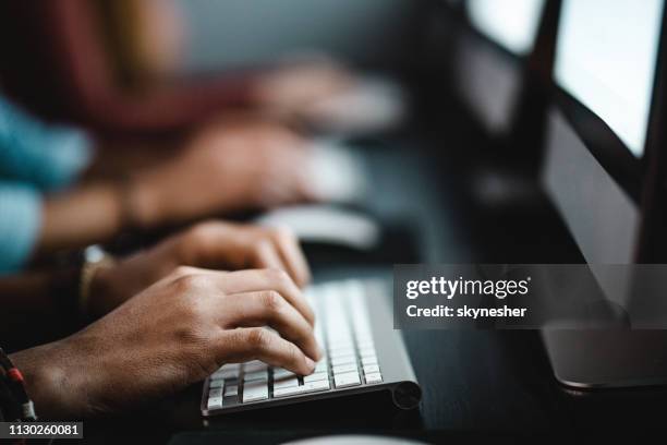 cerca de irreconocible hombre escribiendo correo electrónico en la pc de escritorio. - computer lab fotografías e imágenes de stock