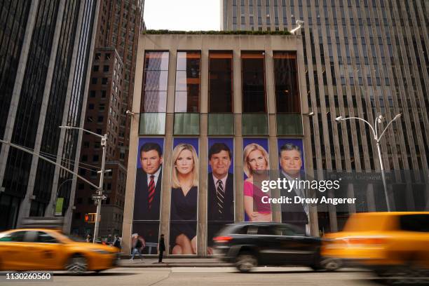 Traffic on Sixth Avenue passes by advertisements featuring Fox News personalities, including Bret Baier, Martha MacCallum, Tucker Carlson, Laura...