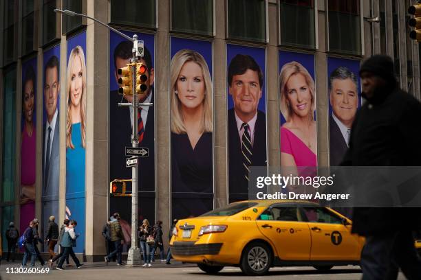 Advertisements featuring Fox News personalities, including Tucker Carlson, adorn the front of the News Corporation building, March 13, 2019 in New...