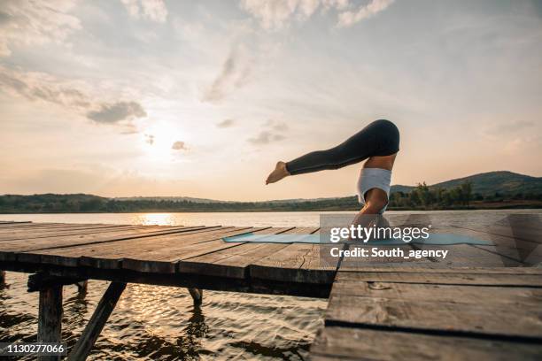 woman exercises yoga by the lake - blonde yoga stock pictures, royalty-free photos & images