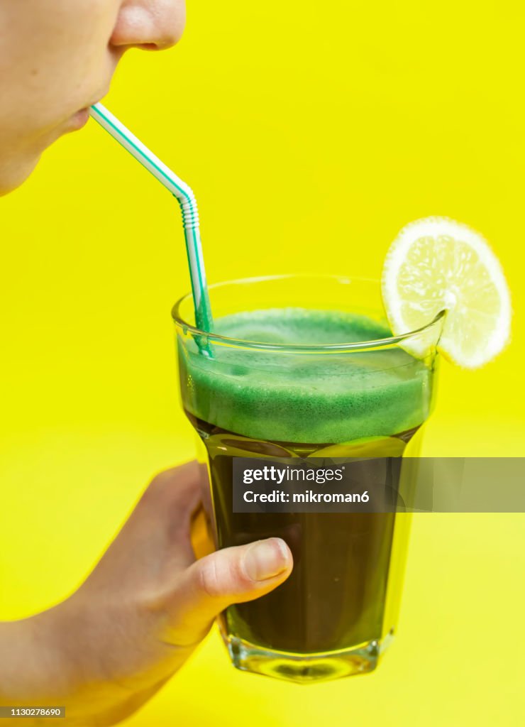 Green smoothie. Young woman drinking vegetable, green smoothie