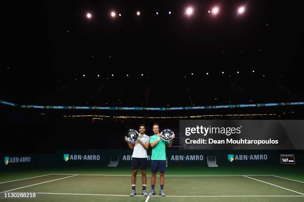 Jeremy Chardy of France and Henri Kontinen of Finland celebrate victory with the trophy against Jean-Julien Rojer of the Netherlands and Horia Tecau...