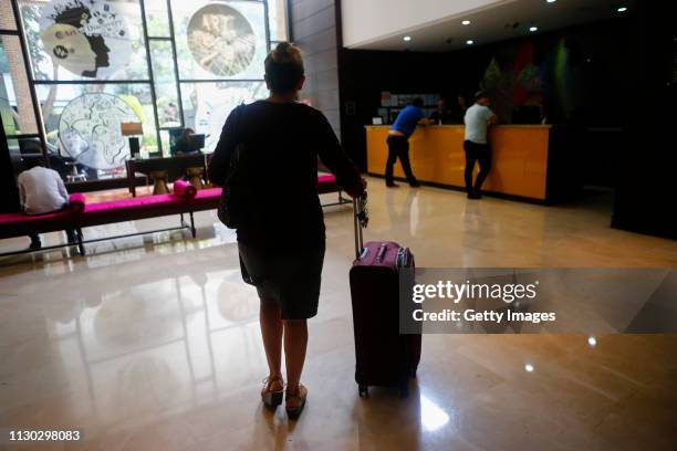 Carolina walks to the hotel's reception with a suitcase full of dirty clothes and will return to the hotel with clean clothes on March 13, 2019 in...