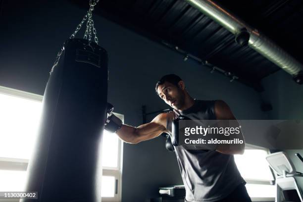 geconcentreerde jongeman vak opleiding in de sportschool - boxing stockfoto's en -beelden