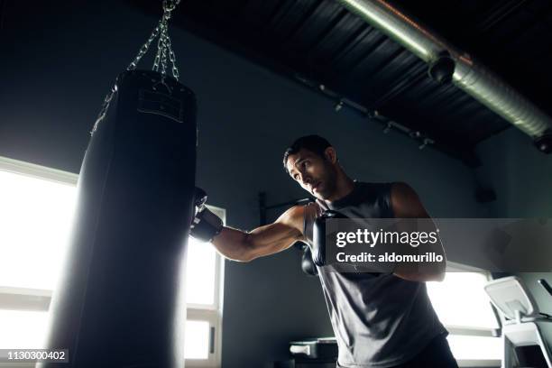 concentrated young man box training in the gym - boxee stock pictures, royalty-free photos & images