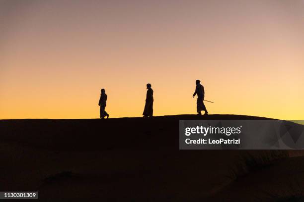 arabes dans le désert au sommet de la dune de sable - arabian desert adventure night photos et images de collection