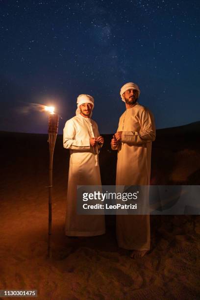 arabes en vêtements traditionnels pendant la nuit dans le désert - arabian desert adventure night photos et images de collection