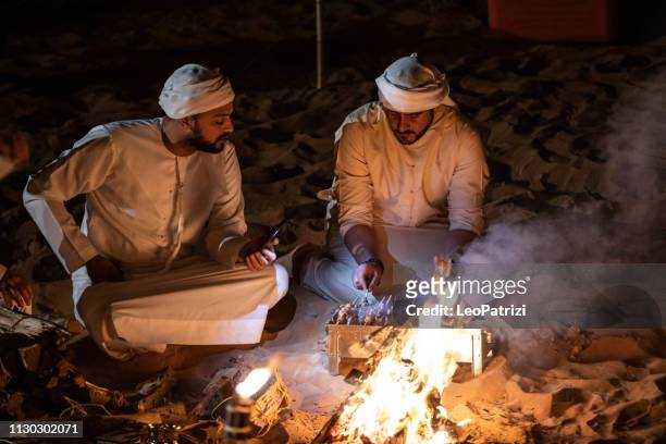 arabs camping at night in the desert - middle eastern male on phone isolated stock pictures, royalty-free photos & images