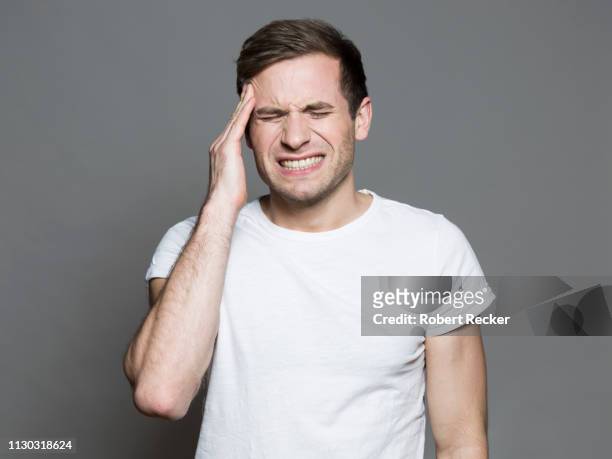 young man having a headache - man headache bildbanksfoton och bilder