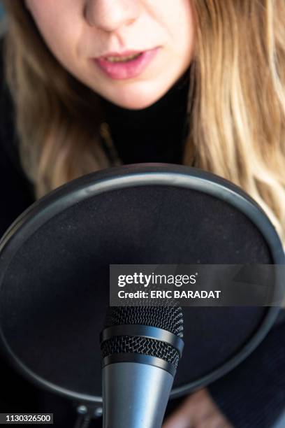 Journalist talks into a microphone on March 12, 2019 in Washington. - Tapping fingernails triggering goosebumps, whispers sending shivers down the...