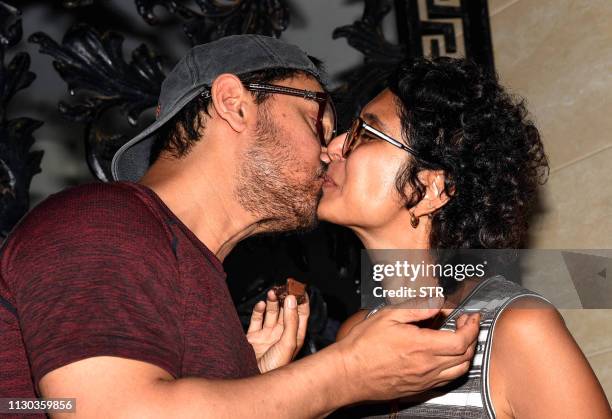 Indian Bollywood actor and producer Aamir Khan and his wife, film director and screenwriter Kiran Rao Khan kiss each other, on his 54th birthday at...