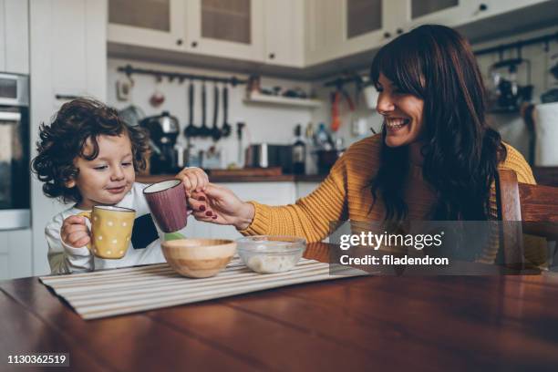 bambino e mamma sul tavolo - soup home foto e immagini stock