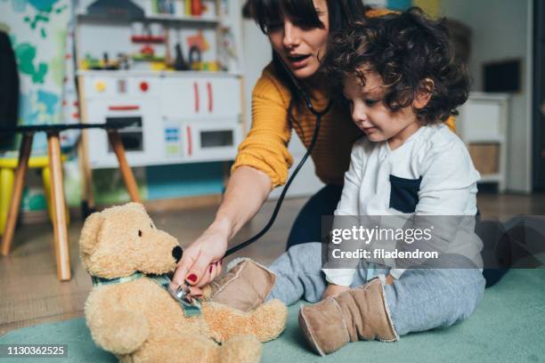 mutter und sohn spielen arzt - child teddy bear stock-fotos und bilder