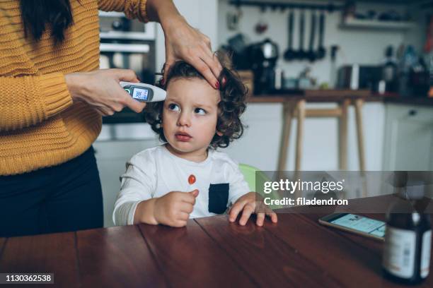 measuring little boy's temperature - baby ear infection stock pictures, royalty-free photos & images