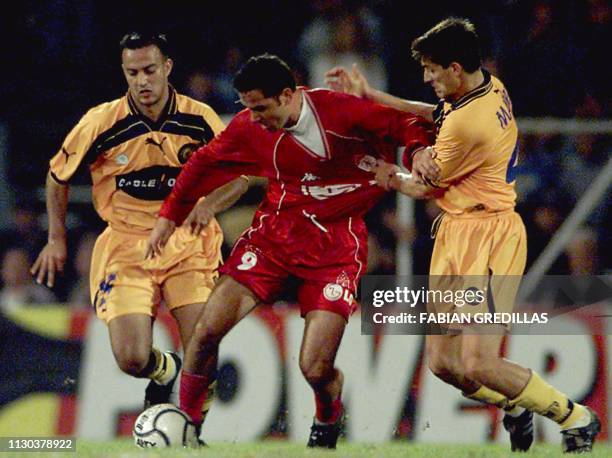 Julian Vasquez of the team America de Cali fights for the ball with Daniel Quinteros and Dario Marra of Rosario Central, 22 May 2001, in a...