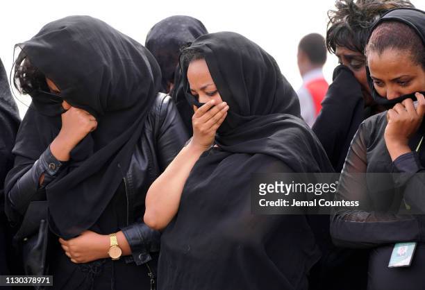 Mourners, believed to be Ethiopian Airlines cabin crew members, arrive to pay their respects at the crash site of Ethiopian Airlines Flight ET302 on...