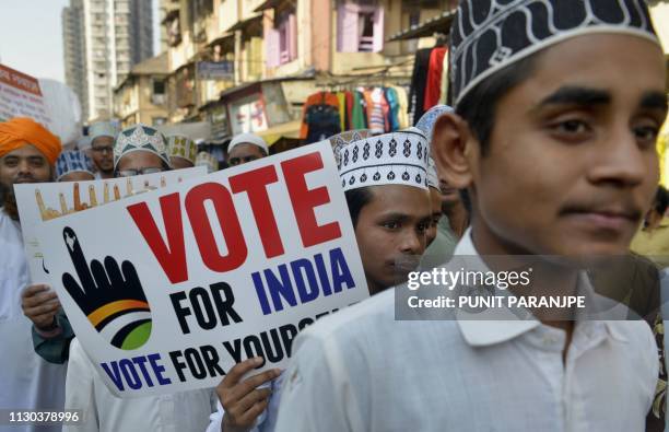 Indian Muslim youth hold placards during a rally to urge people to vote in Mumbai on March 14, 2019. - India announced on March 10 a general election...