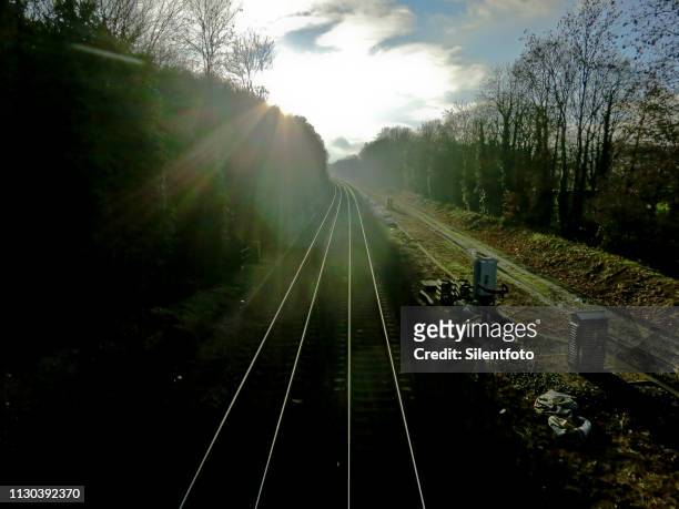 train tracks under a moody sky - impending stock pictures, royalty-free photos & images