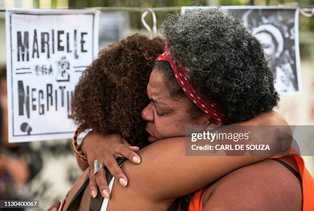 Women embrace during a protest marking one year of the death of Brazilian councilwoman Marielle Franco, at the site where she was murdered in Rio de...