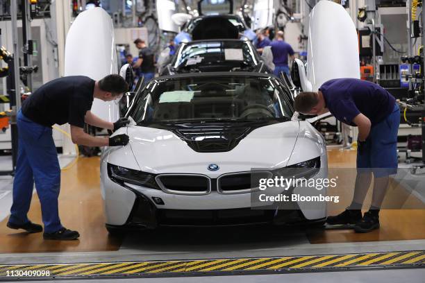 Employees fit a hood to a BMW i8 hybrid electrical automobile at the Bayerische Motoren Werke AG factory in Leipzig, Germany, on Thursday, March 14,...