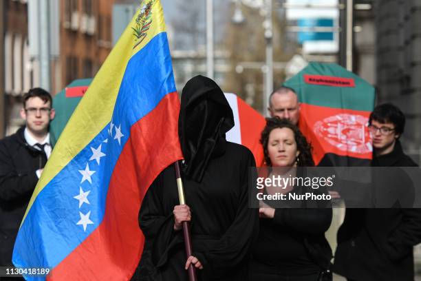 The Grim Reaper with Venezuelan flag leads a funeral cortege including coffins draped in the flags of Syria, Afganistan and Libya, and Eilis Ryan,...