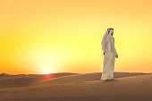 Arab man admiring expansive dunes during sunset