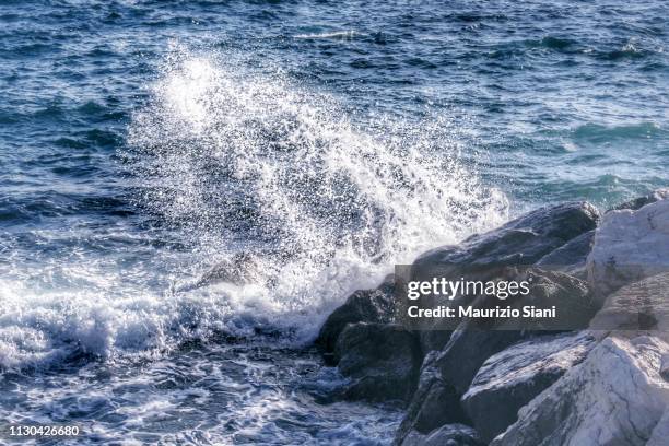 waves splashing on rocks - astratto stock-fotos und bilder