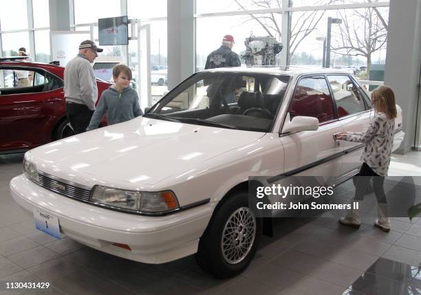 Visitors to the Toyota Motor Manufacturing plant look over the first U.S built 1988 Toyota Camry at the Georgetown plant as they wait for the...