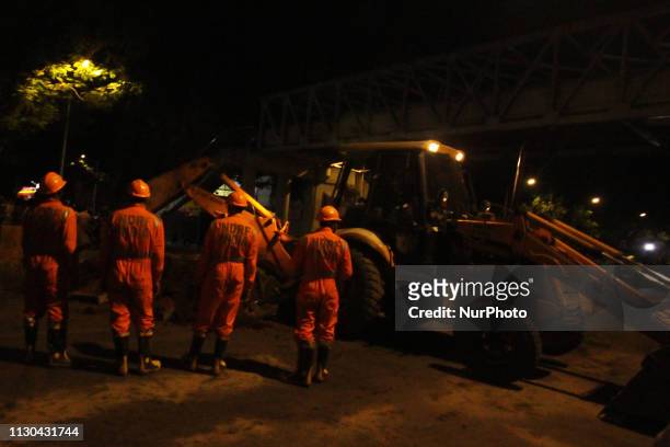 Rescue workers stand at the site of a footbridge after its collapse, outside the Chhatrapati Shivaji Maharaj Terminus railway station in Mumbai,...